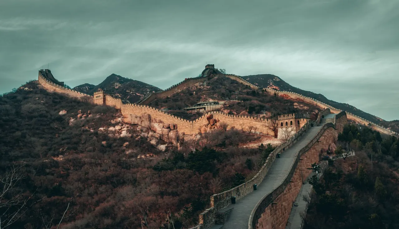Stunning view of the Great Wall of China stretching across rugged mountains under an overcast sky.