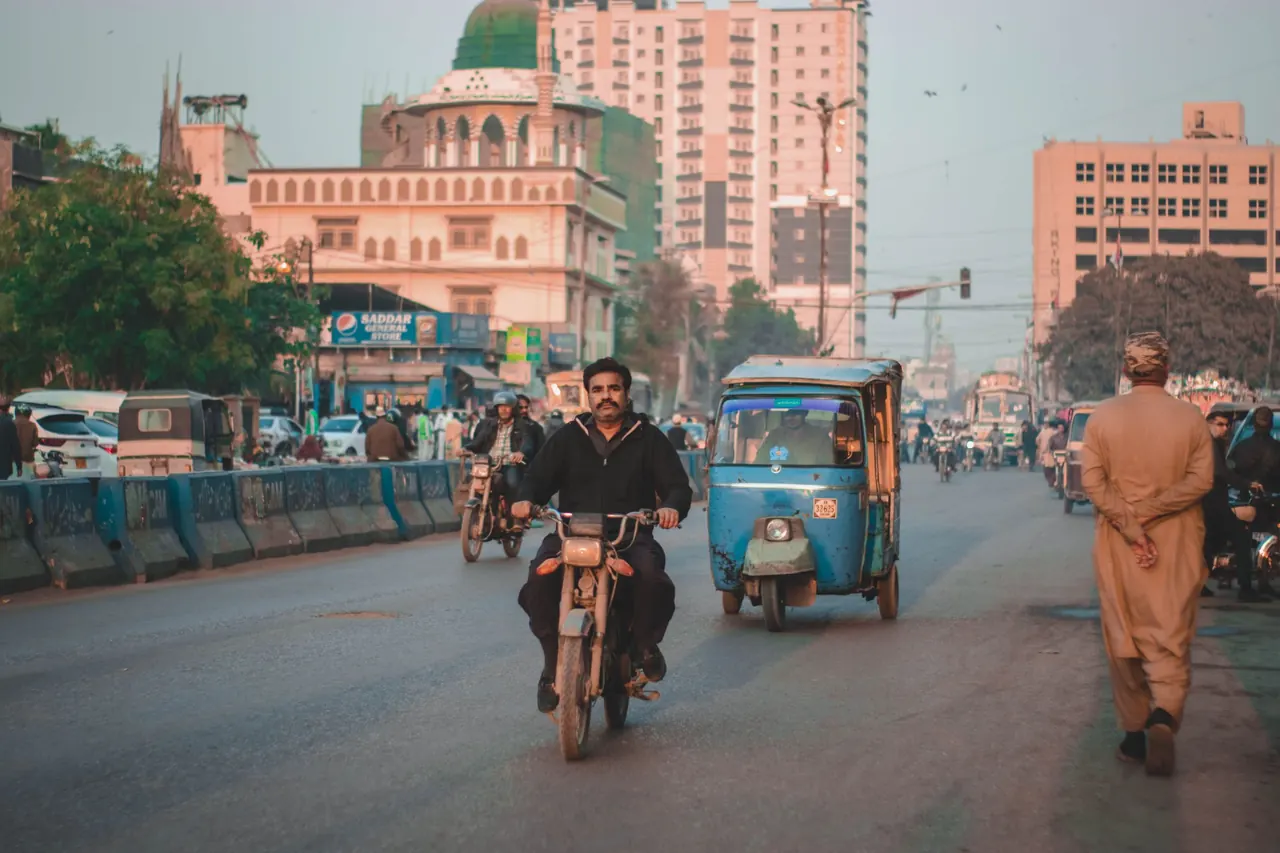 Crowded urban street scene with motorbikes and rickshaws. Vibrant city life captured outdoors.