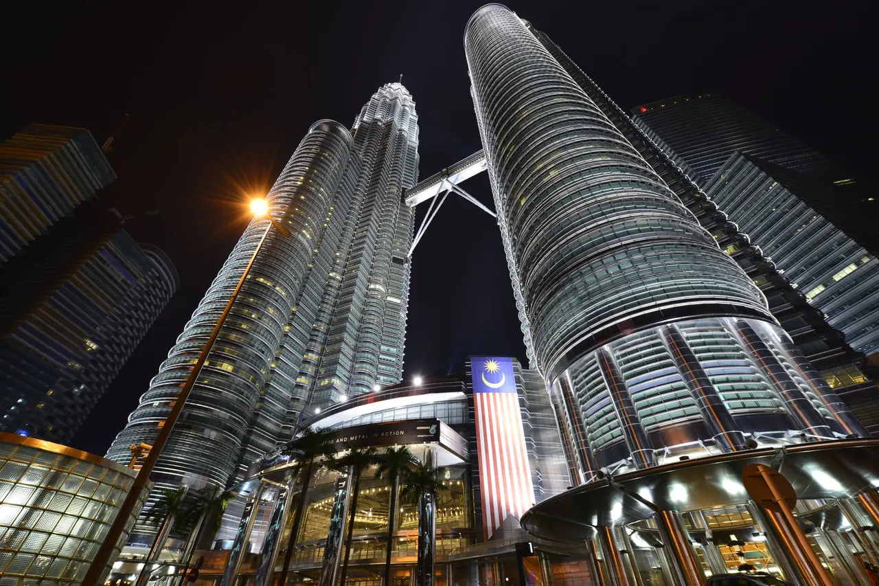 Stunning low angle view of the illuminated Petronas Twin Towers in Kuala Lumpur, Malaysia at night.
