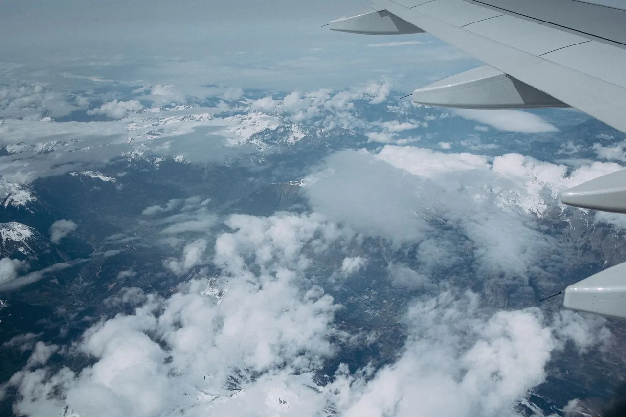 Cloud-filled aerial view of scenic mountains from airplane above Barcelona, Spain.